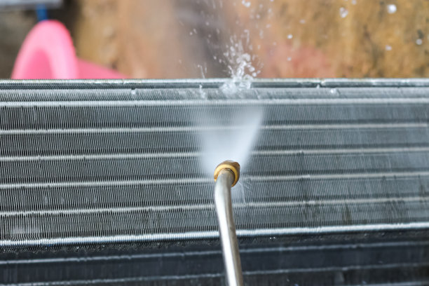 用高压水清洗空调盘管面板的照片，概念维护和维修空调。图片下载