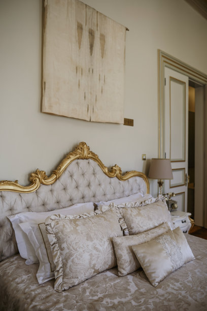 豪华的皇家卧室内部配有床、枕头和米色墙壁。库存图片图片下载
