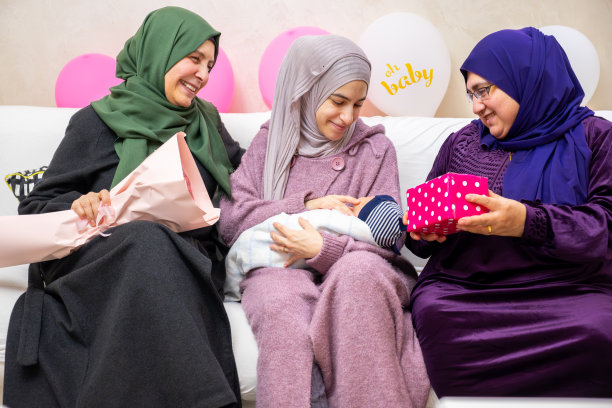 母亲和婆婆庆祝新生儿，拿着礼物，周围是气球图片下载