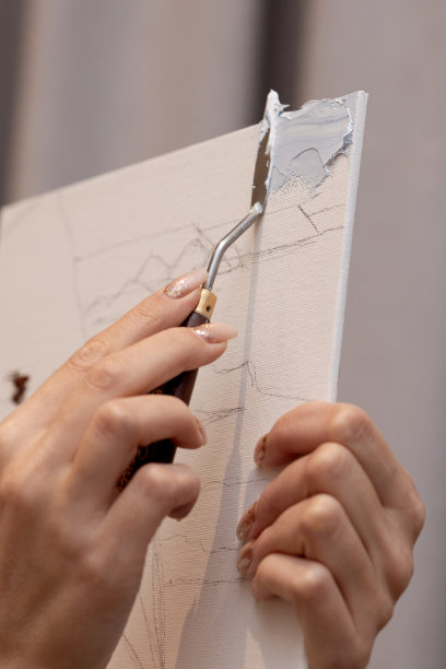 老师展示了如何用调色板刀把颜料涂到画布上图片下载