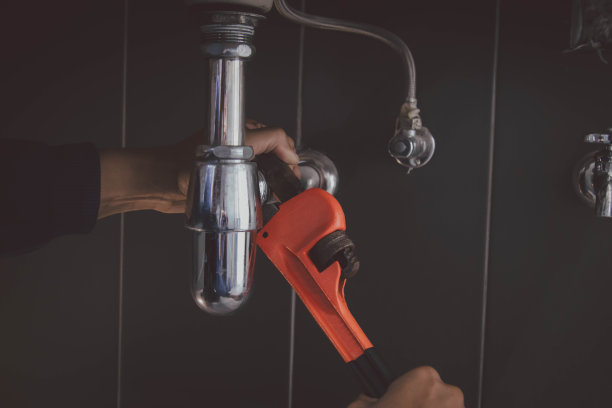 在浴室工作的水管工，管道维修服务，修理水管道泄漏，更换厨房水槽排水管图片下载