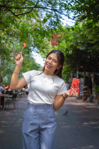 年轻的女上班族下班后拿着西瓜吃得又兴奋又开心图片下载