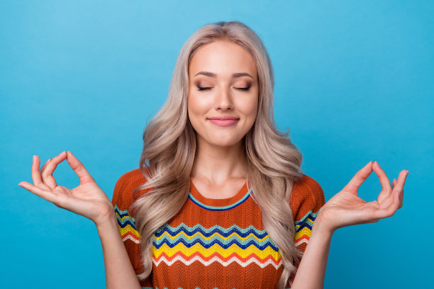 照片的梦幻可爱的女孩穿着印花衬衫闭着眼睛练习瑜伽孤立的蓝色背景图片下载