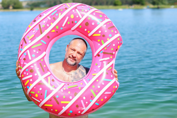 一位中年男子透过充气环望向大海图片下载
