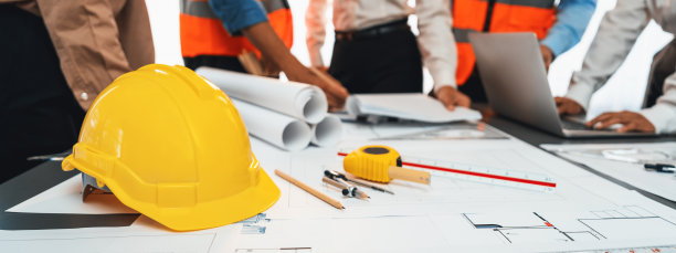 工程师工具，安全帽和图纸放在会议桌上。洞察力图片下载