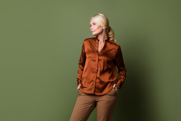 漂亮的退休女性手的照片肖像口袋看起来空的空间穿时髦的缎面棕色衣服孤立的卡其色背景图片下载