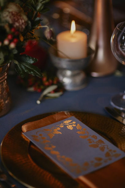 波希米亚风格的婚礼餐桌，装饰着一个蓝色覆盖的青铜花瓶和石榴雕像。库存图片图片下载