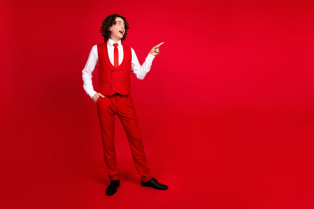 优雅的青少年男友邀请女孩参加大学毕业舞会的全身照片，在红色背景上用手指隔开了空白的空间图片下载