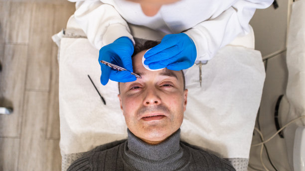 中年白人男子在美容院用手拔眉毛图片下载