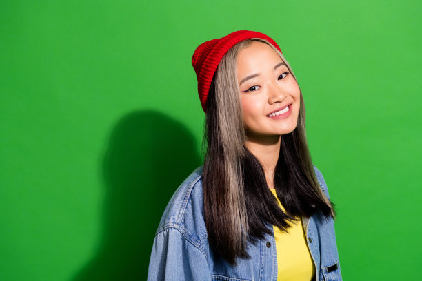 照片中漂亮可爱的女孩穿着牛仔裤衬衫微笑着洁白的牙齿空白空间孤立绿色背景图片下载