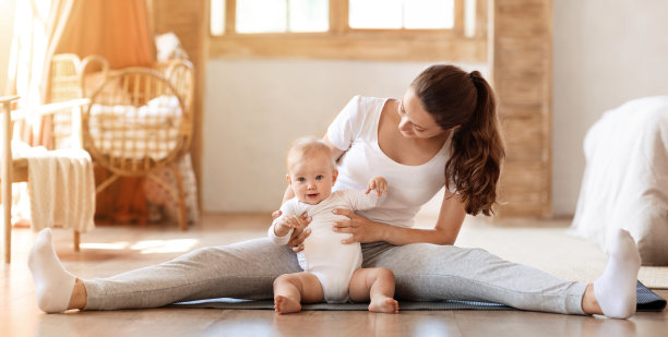 年轻女子在家带着小儿子练习瑜伽图片下载
