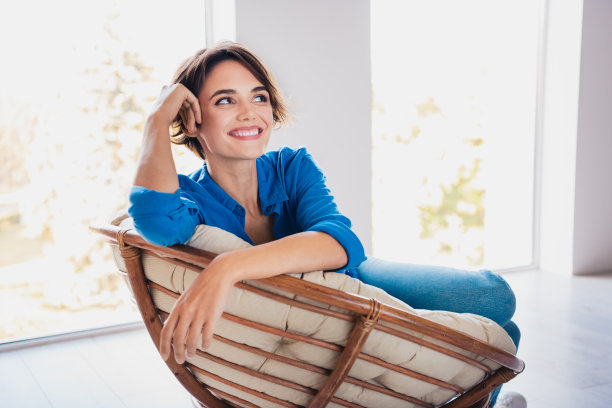 照片正面漂亮的女孩坐在舒适的软椅享受周末独自现代室内房间图片下载