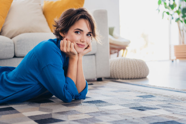 照片的华丽可爱的好心情的女孩躺在舒适的地毯客厅现代室内室内图片下载