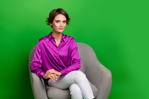 年轻女士的照片坐在扶手椅在办公室听有趣的候选人简历简历生活史孤立的绿色背景图片下载