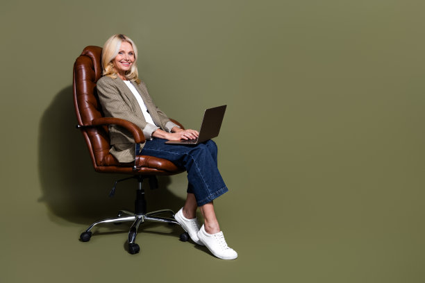 全尺寸的身体照片的专业商务女士工作在自由市场外包坐扶手椅孤立的卡其色背景图片下载