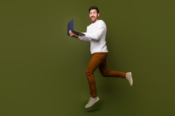 穿着时髦衣服的快乐的好男人在卡其色背景上跑步匆忙的办公室的全身照片图片下载