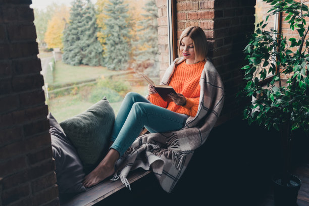 平和积极的女孩的全尺寸照片光着脚坐在窗台上盖着毯子看书自由时间房子在室内图片下载