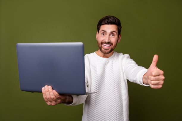 有吸引力的大胡子漂亮开朗的男人的照片推荐购买上网本大拇指孤立的卡其色背景图片下载