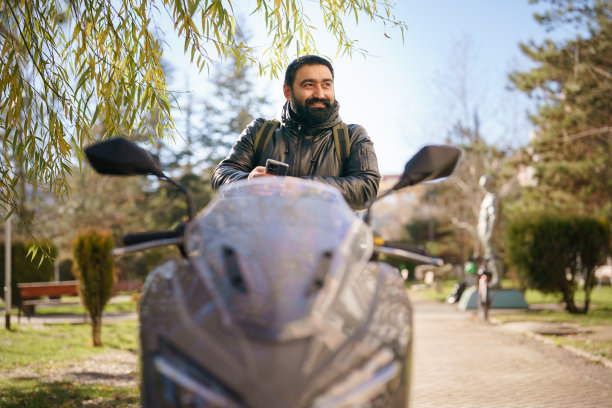 在街上用手机的摩托车男人图片下载