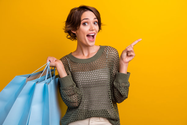 迷人时髦的女孩穿着时髦的衣服的照片建议提供商店，商场空空间孤立的黄色背景图片下载