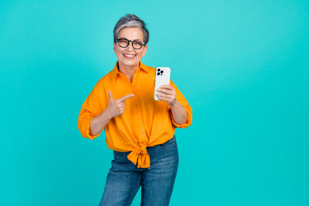 乐观的老年商业妇女的照片证明她的新苹果手机是原装的，在青色背景上孤立的手指小工具图片下载