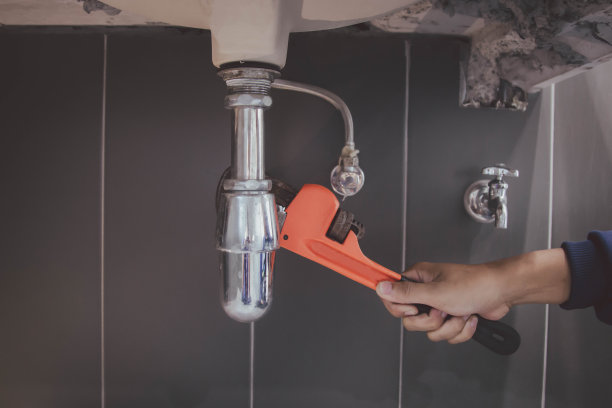 在浴室工作的水管工，管道维修服务，修理水管道泄漏，更换厨房水槽排水管图片下载