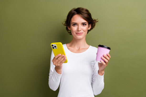 可爱的年轻女士的照片肖像拿着纸杯咖啡装置穿着时髦的白色服装孤立的卡其色背景图片下载