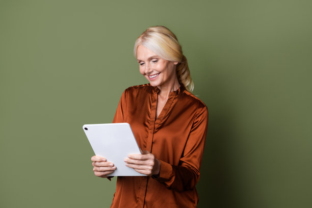 可爱的资深女士的照片肖像电子书企业家穿着时尚的棕色丝绸服装孤立的卡其色背景图片下载