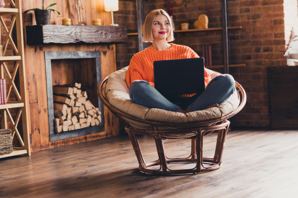 有创意的漂亮女孩的全尺寸照片，坐在椅子上，使用笔记本电脑，看起来很好奇，头脑风暴阁楼室内房子在室内图片下载