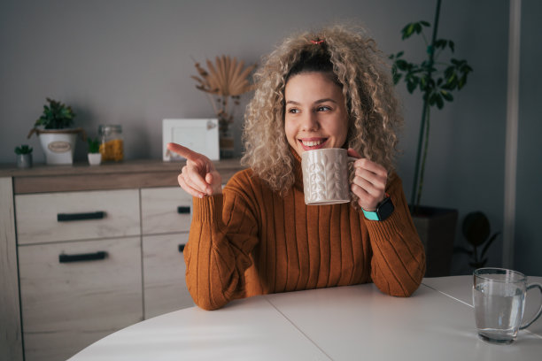 卷发的女人享受着一杯咖啡图片下载