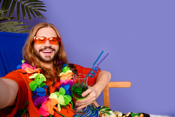 照片上，一个长着牙齿、笑容满面、乐观向上的男人，戴着太阳镜，在紫色的背景下，手掌下拿着鸡尾酒自拍图片下载