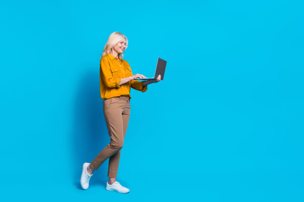 退休妇女的全身照片instagram推特facebook电报穿着时髦的黄色丝绸衣服在蓝色的背景中孤立图片下载