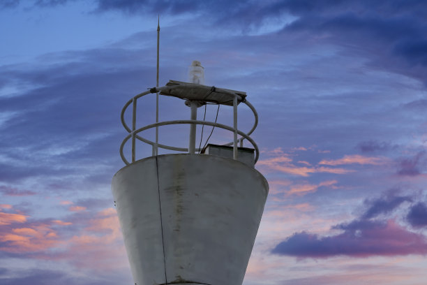 蓝色的天空下，铁灯塔矗立在港口的边缘图片下载