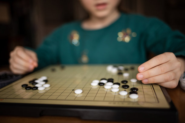 孩子在玩围棋游戏。开发思维的棋盘逻辑策略游戏图片下载