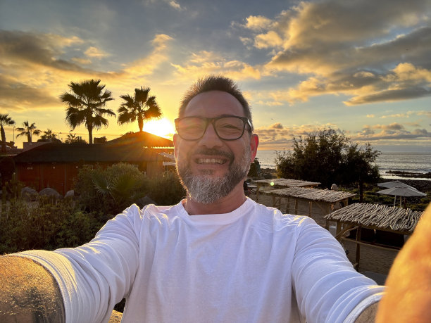 一名游客微笑着用手机连接自拍照片分享到社交媒体上。人们和旅游避暑目的地的概念。生活方式和户外休闲活动图片下载