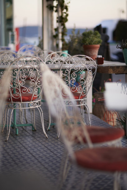 咖啡馆里带橙色靠垫的熟铁椅子。库存图片图片下载