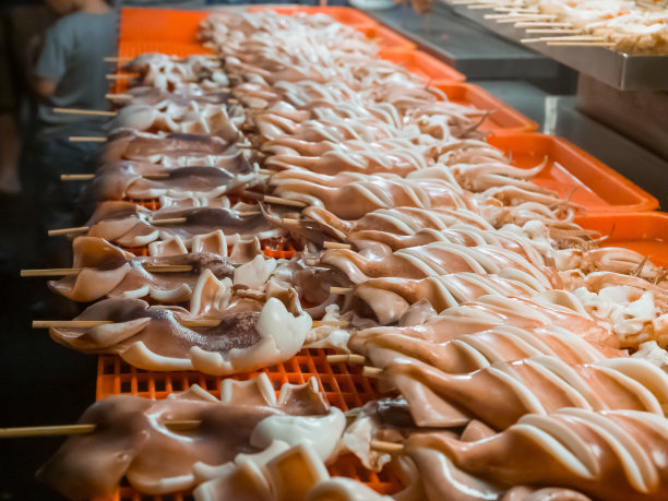 在台湾当地市场，为游客准备的托盘里装满了新鲜的墨鱼，可供烹饪或烧烤图片下载