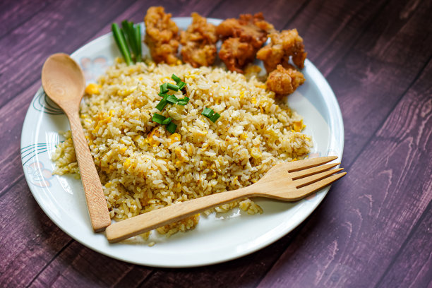 自制菜单图片:餐桌上的盘子里放着鸡蛋炒饭和炸鸡图片下载