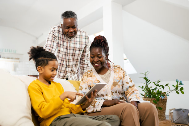 一对非裔美国老年夫妇和他们的孙子一起看动画片图片下载
