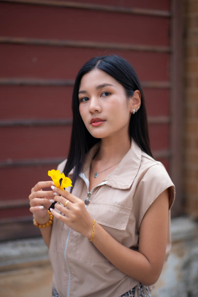 一个十几岁的女孩穿着复古的连衣裙，拿着一朵黄色的花，用高傲的眼神看着你。图片下载