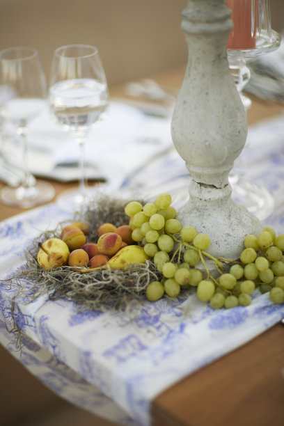 餐桌上的大烛台下面摆着葡萄和水果。库存图片图片下载