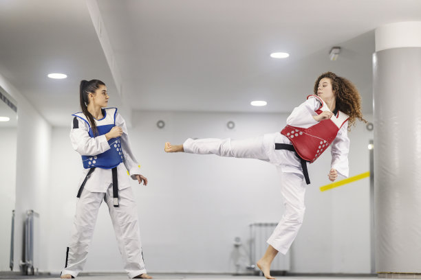 跆拳道运动员穿着跆拳道服，在武术学校练习格斗、攻击和防御。图片下载