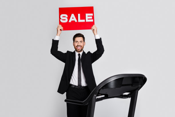 照片正面优雅的人站在跑步机手拿销售标书空白空间孤立的灰色背景图片下载