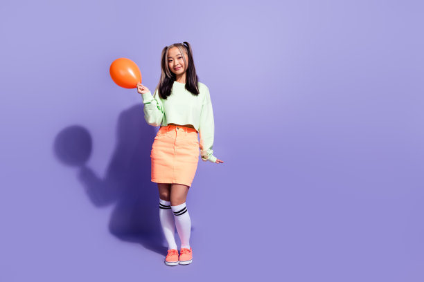可爱的韩国女孩玩气球的全身长度的照片享受自由的时间在户外孤立的紫罗兰色背景图片下载