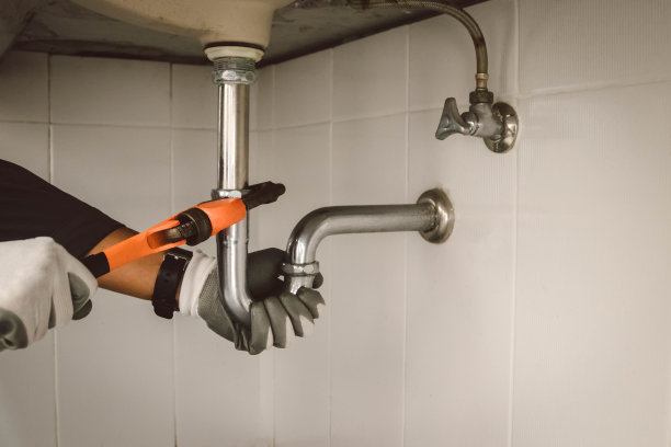 在浴室工作的水管工，管道维修服务，修理水管道泄漏，更换厨房水槽排水管图片下载