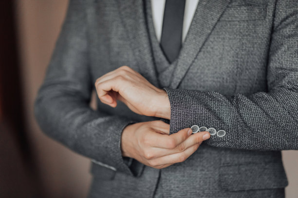 裁剪的照片，一个时髦的男人调整他的夹克。前视图。一块时髦的手表。男人的风格。时尚。业务图片下载