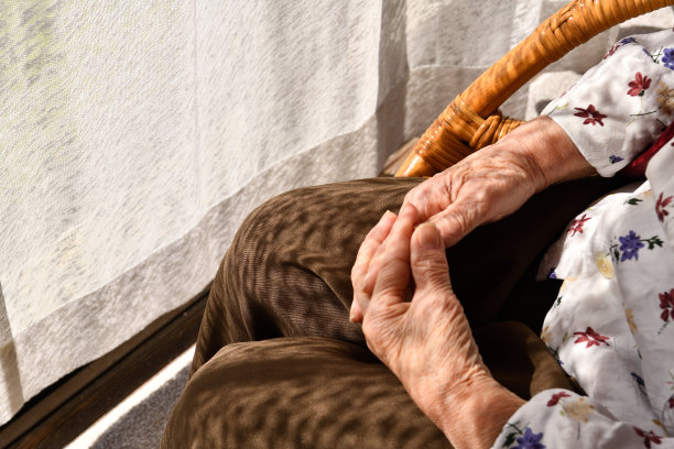 坐在窗边藤椅上的日本老年妇女图片下载