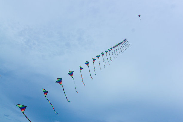 五颜六色的风筝飘过蓝天。图片下载