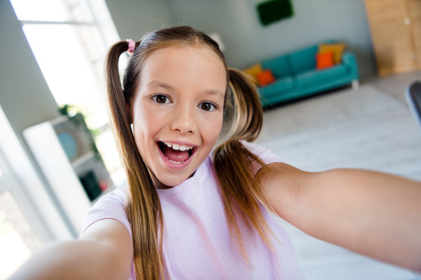 惊讶的时髦学生的照片有好心情，露齿微笑自拍记录视频公寓里面图片下载