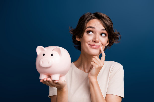 照片上的美女肖像看起来很有魅力，空抱着小猪穿着时尚的白色衣服，孤立在深蓝色的背景上图片下载